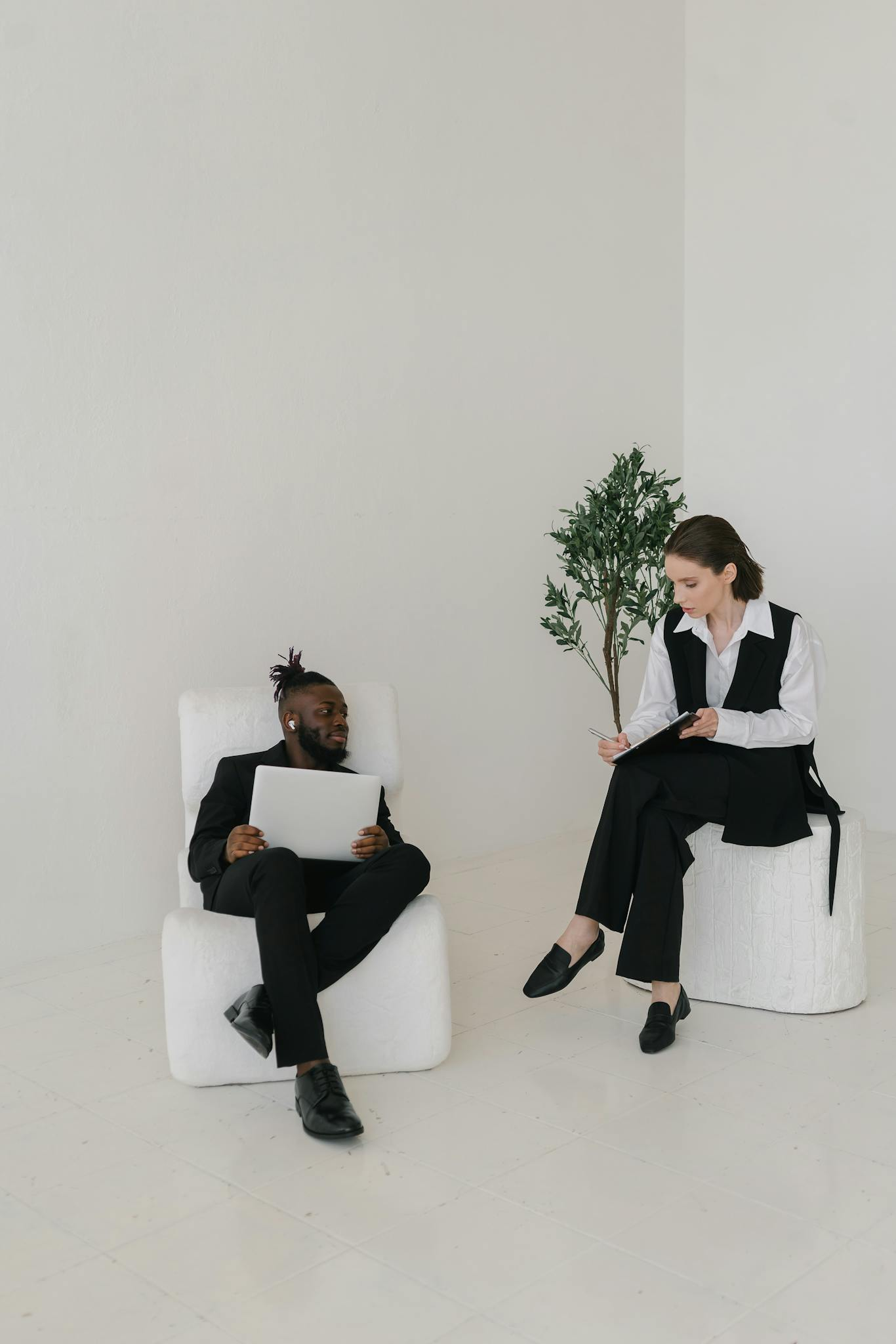 Two colleagues discussing work documents in a bright, modern office setting.